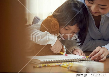 リビングの床に娘のお絵描きを手伝う母親 リビングの床に娘のお絵描きを手伝う母親 51054952