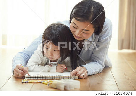 リビングの床に娘のお絵描きを手伝う母親 リビングの床に娘のお絵描きを手伝う母親 51054973