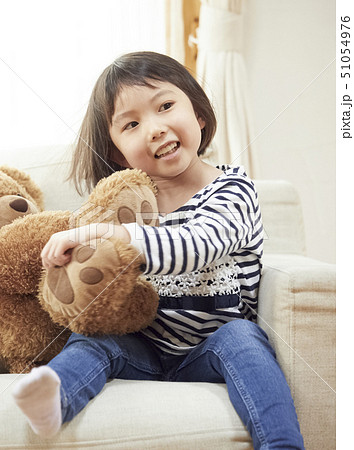 ソファで大きなクマと遊ぶおかっぱ頭の女の子 51054976
