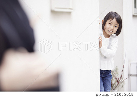 家の外で出張に出掛ける母を見送る娘 51055019