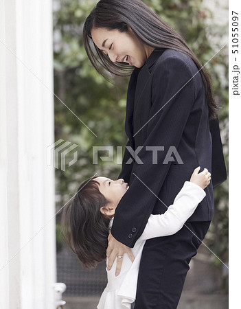 家の外でただいまの抱擁をする母娘 51055097