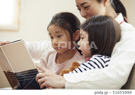 ソファで先生に読み聞かせをしてもらう子供達 51055099