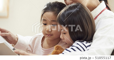 ソファで先生に読み聞かせをしてもらう子供達 51055117
