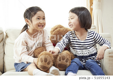 ソファで大きなクマと遊ぶ姉妹 51055143