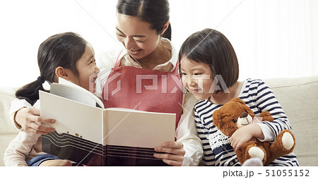 ソファで先生に読み聞かせをしてもらう子供達 51055152