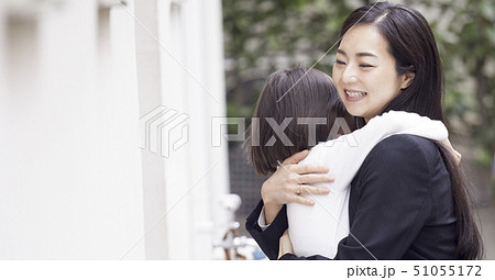 家の外でただいまの抱擁をする母娘 家の外でただいまの抱擁をする母娘 51055172