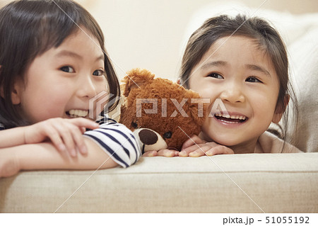 ソファの肘掛けに首を乗せ寄り添う子供たち ソファの肘掛けに首を乗せ寄り添う子供たち 51055192