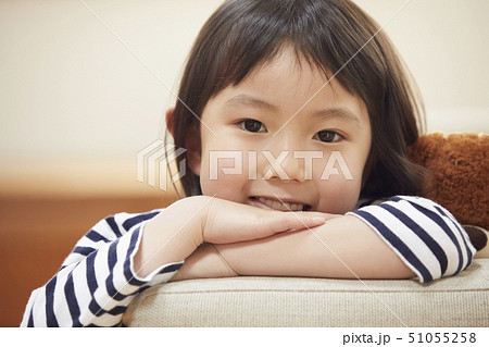 カメラ目線でソファの肘掛けに首を乗せる子供 51055258