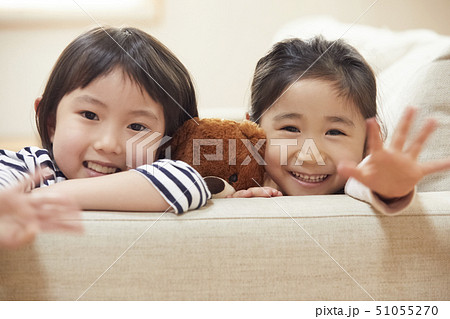 ソファの肘掛けに首を乗せ寄り添う子供たち 51055270