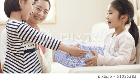 お誕生日にお母さんと妹からプレゼントをもらう女の子の写真素材 お誕生日にお母さんと妹からプレゼントをもらう女の子の写真素材