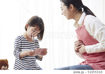 床にお座りしてトランプをする先生と子供 51055310