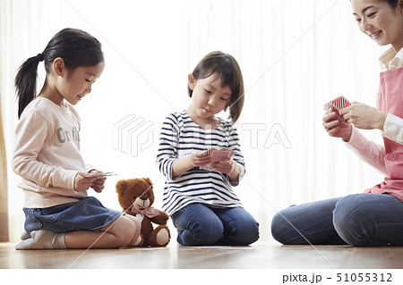 床にお座りしてトランプをする先生と子供たち 51055312