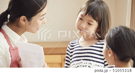 床にお座りして問題を出す先生とそれに答える子供たち 51055318