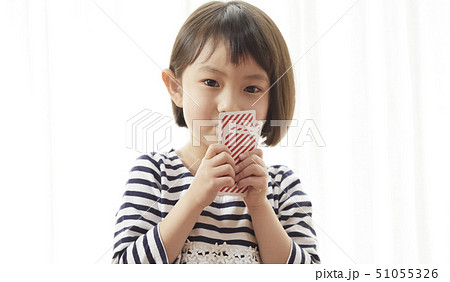 トランプで口を隠す女の子 51055326