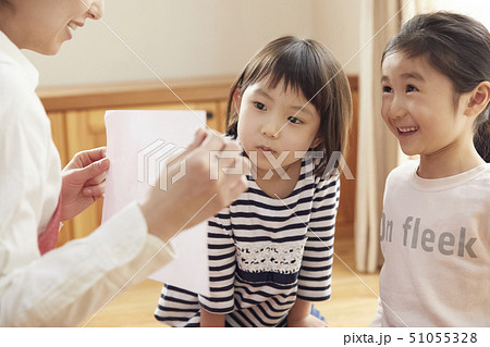 床にお座りして問題を出す先生とそれに答える子供たち 51055328