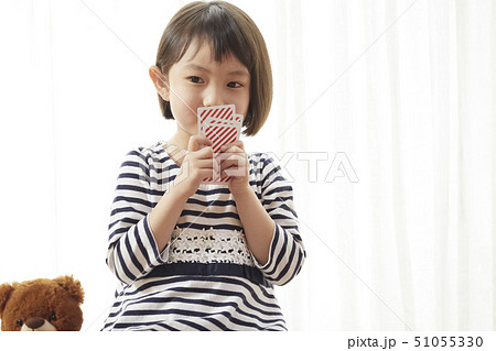 トランプで口を隠す女の子 51055330