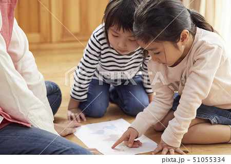 床にお座りして問題を出す先生とそれに答える子供たち 51055334