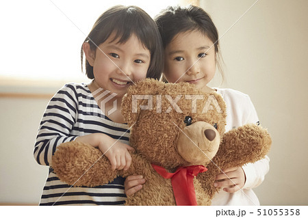 カメラ目線で大きなクマを抱っこする子供たち 51055358