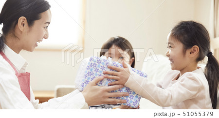 お誕生日にお母さんと妹からプレゼントをもらう女の子 51055379