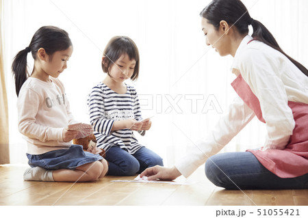 床にお座りしてトランプをする先生と子供たち 51055421
