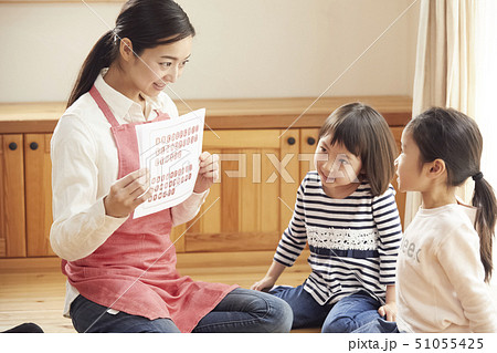 床にお座りして問題を出す先生とそれに答える子供たち 51055425