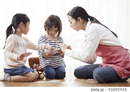 床にお座りしてトランプをする先生と子供たち 51055433