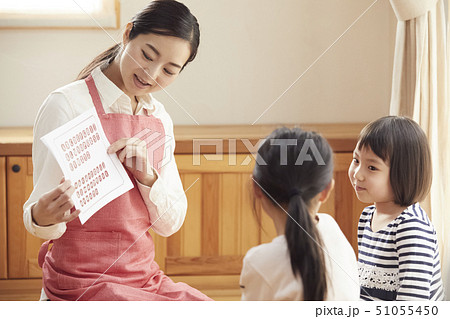 床にお座りして問題を出す先生とそれに答える子供たち 51055450