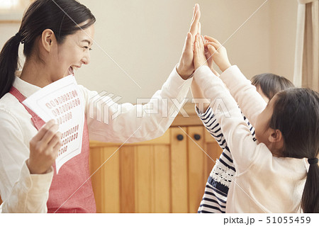 床にお座りして問題を出す先生とそれに答える子供たち 51055459
