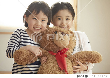 カメラ目線で大きなクマを抱っこする子供たち 51055465