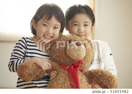 カメラ目線で大きなクマを抱っこする子供たち カメラ目線で大きなクマを抱っこする子供たち 51055482