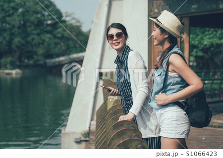 tourists enjoy sunshine pond view in park smiling tourists enjoy sunshine pond view in park smiling 51066423