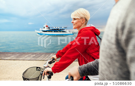 Midsection of young couple with bicycles cycling outdoors on beach. Midsection of young couple with bicycles cycling outdoors on beach. 51086630