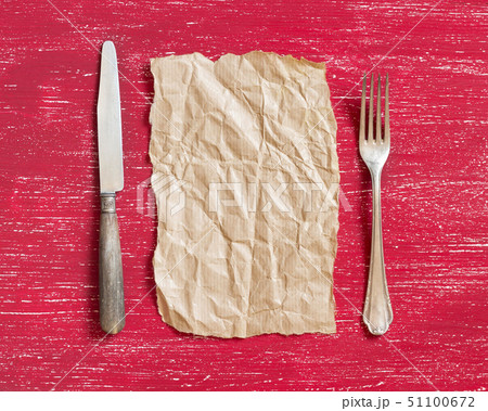 Vintage fork and knife with craft paper on red Vintage fork and knife with craft paper on red 51100672