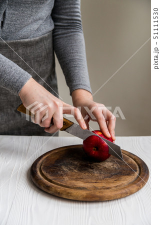 Woman cuts red apple on board close Woman cuts red apple on board close 51111530