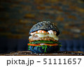 Black burger with prawns on wooden board 51111657