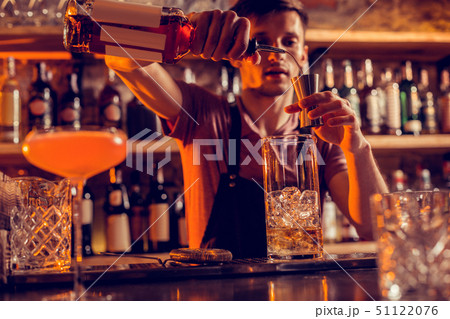 Busy barman making cocktails for clients at night 51122076