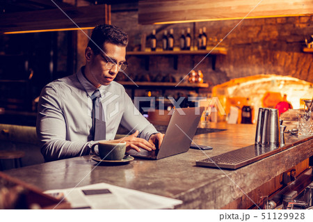 Freelancer sitting in his restaurant and working on laptop 51129928