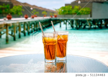 Iced tea against tropical Overwater Bungalow Resort. 51134463
