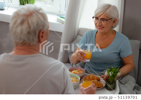 Glowing wife having juice and cereals breakfast with her spouse 51139701