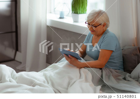 Nice-appealing lady watching a movie while lying in the bed Nice-appealing lady watching a movie while lying in the bed 51140801