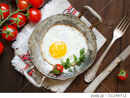 Fried egg with tomatoes and herbs n a old frying 51146712