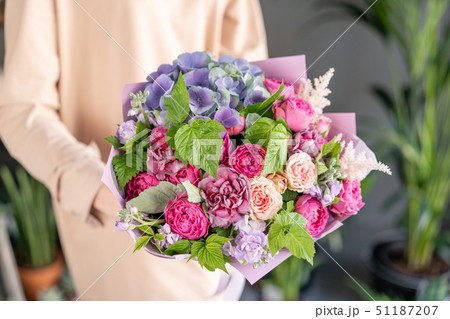 Small Beautiful bouquet of mixed flowers in woman hand. Floral shop concept . Beautiful fresh cut Small Beautiful bouquet of mixed flowers in woman hand. Floral shop concept . Beautiful fresh cut 51187207
