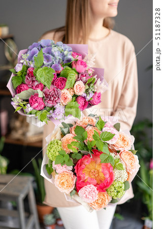 Two Small Beautiful bouquets of mixed flowers in woman hand. Floral shop concept . Beautiful fresh 51187328