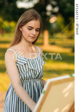 Portrait of Blond hair girl in dress drawing a picture in the park Portrait of Blond hair girl in dress drawing a picture in the park 51195514