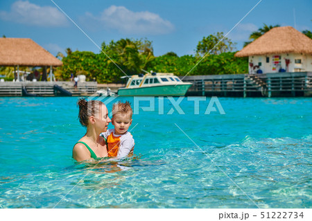 Toddler boy on beach with mother 51222734