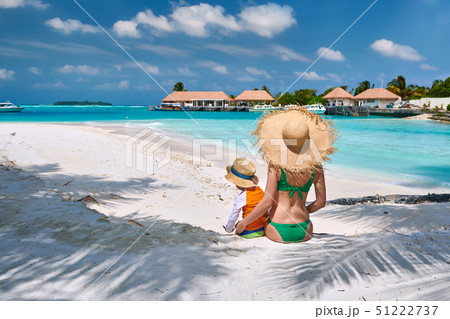 Toddler boy on beach with mother Toddler boy on beach with mother 51222737