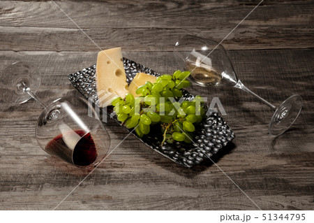 A bottle and glasses of red and white wine with fruits 51344795