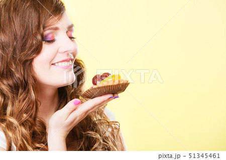 woman closed eyes holds cake in hand 51345461