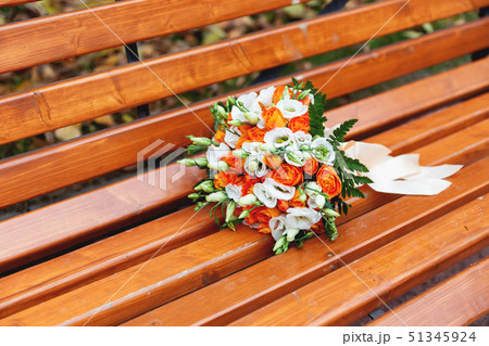 Wedding bouquet on garden bench.  51345924