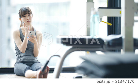 スマホを使う女性　フィットネスジム 51347170
